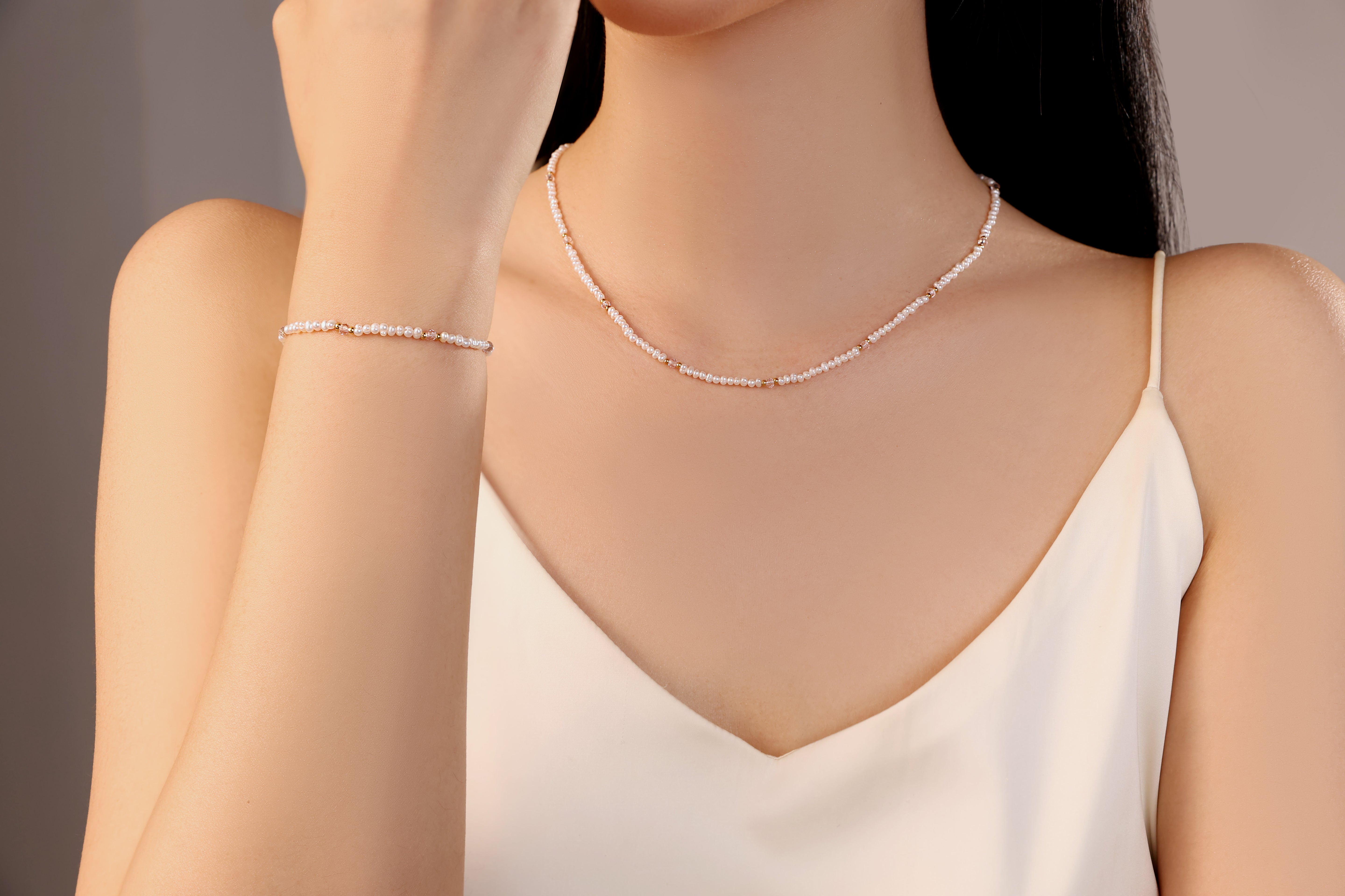model wearing Kaia white freshwater pearl necklace band bracelet with pink gold beads stainless steel