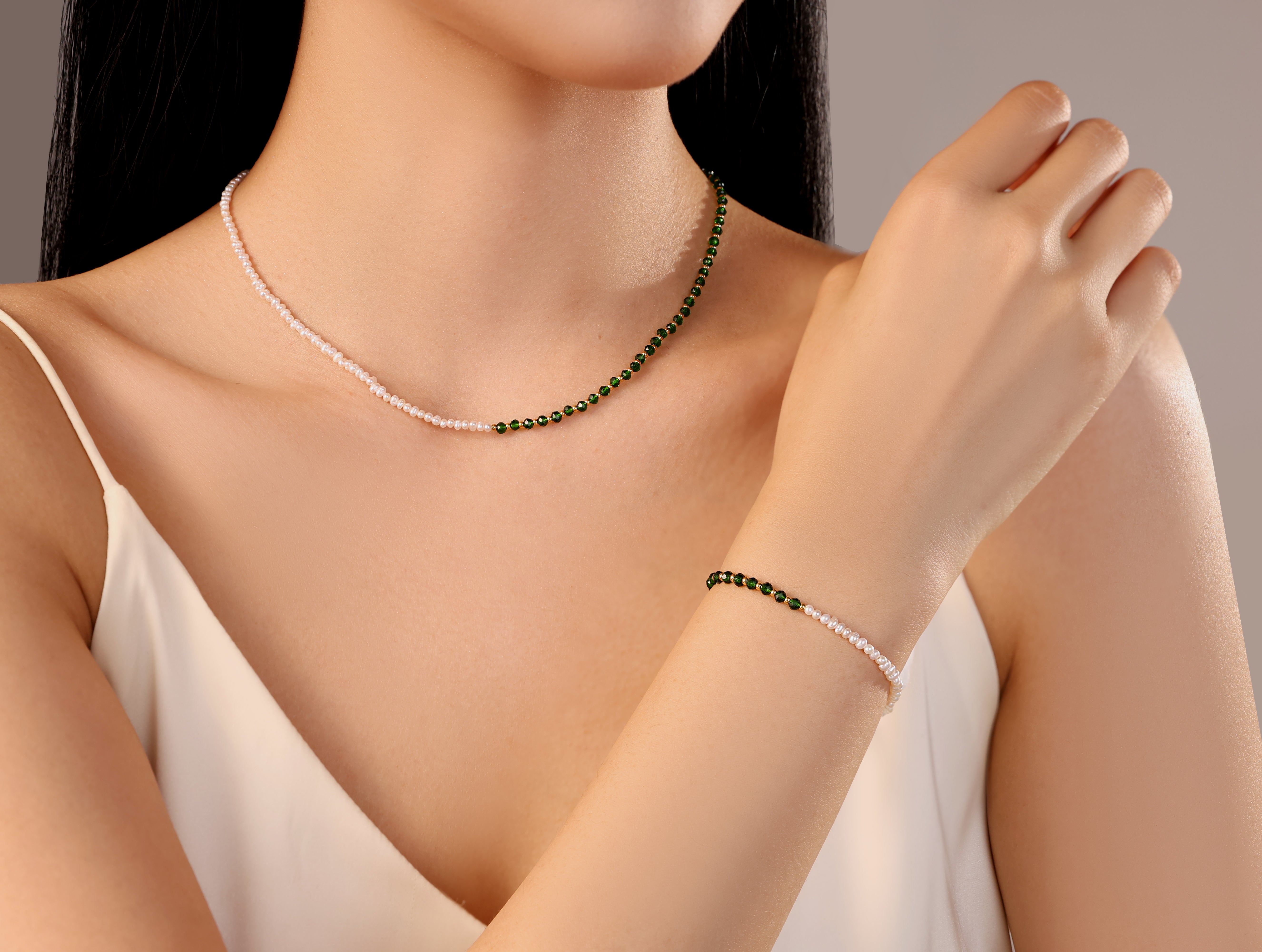 model wearing necklace with white freshwater pearls and green gold stainless steel beads