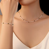 model wearing Kaia white freshwater pearl necklace band bracelet with green gold beads stainless steel