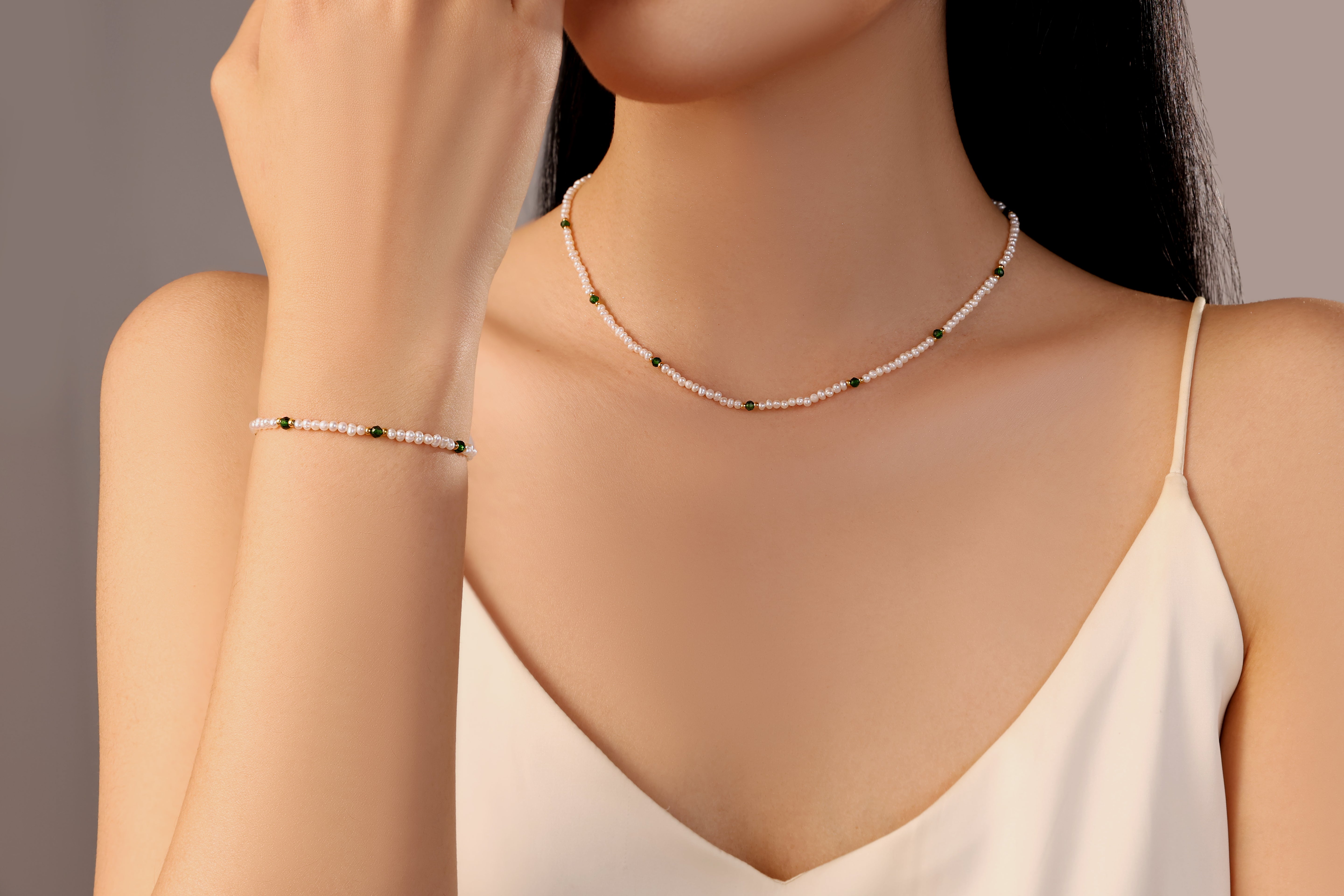 model wearing Kaia white freshwater pearl necklace band bracelet with green gold beads stainless steel