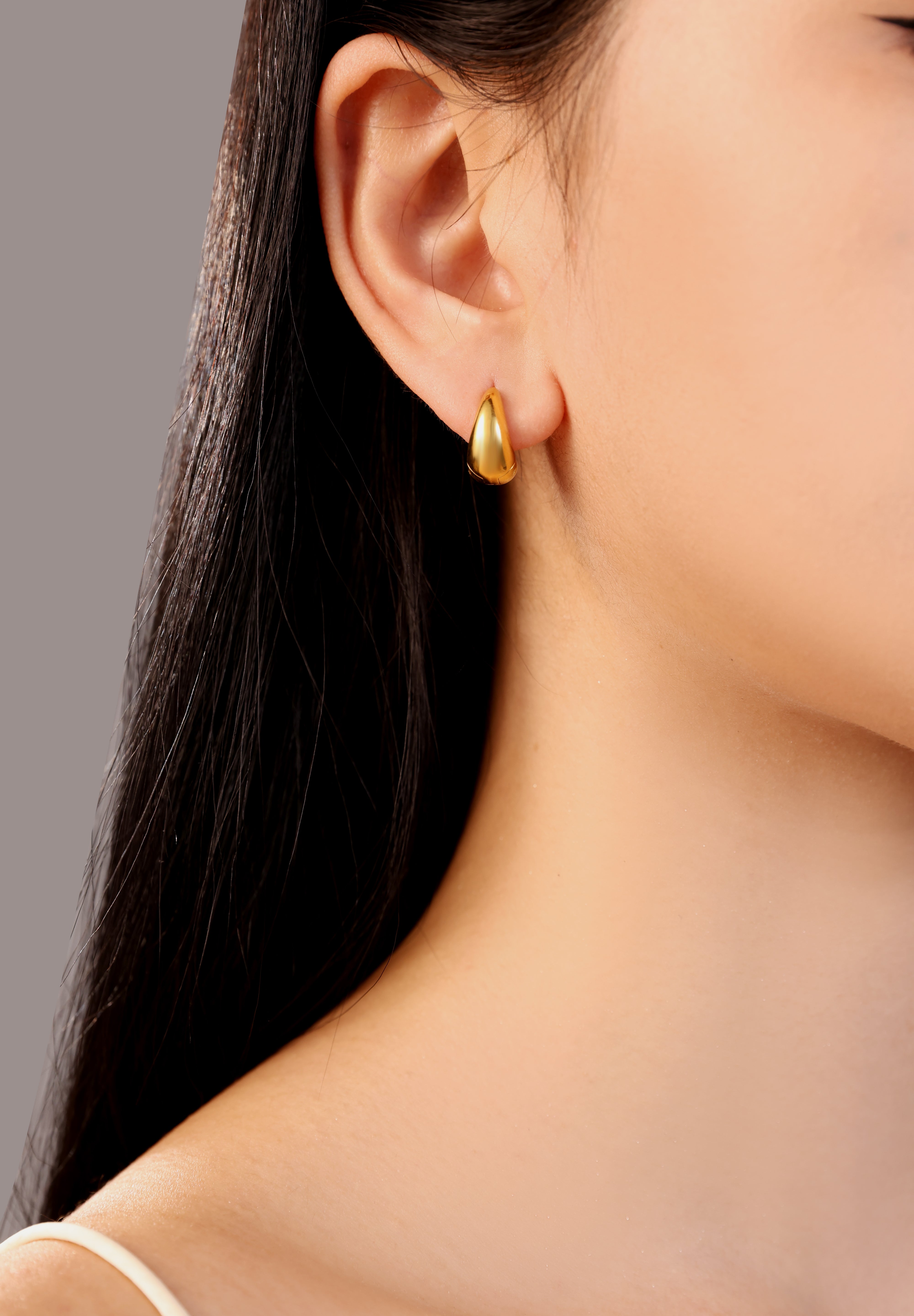 model wearing gold Lucia stainless steel waterproof chunky small hoop earrings