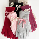 Set of colorful gloves with contrast bow detail on a white background