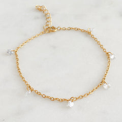 Dainty Gold chain bracelet with small clear crystals on a marble background