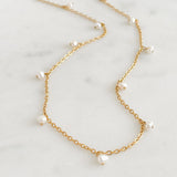 Fine chain necklace with pearls on a marble background