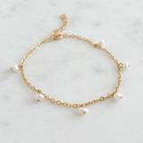 Fine Gold bracelet with small freshwater pearls on a marble background