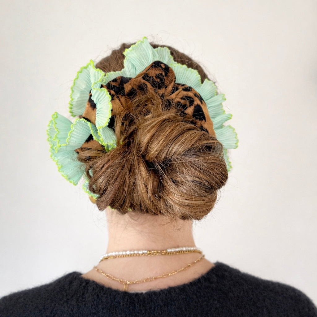 leopard scrunchie with green ruffle trim in models hair