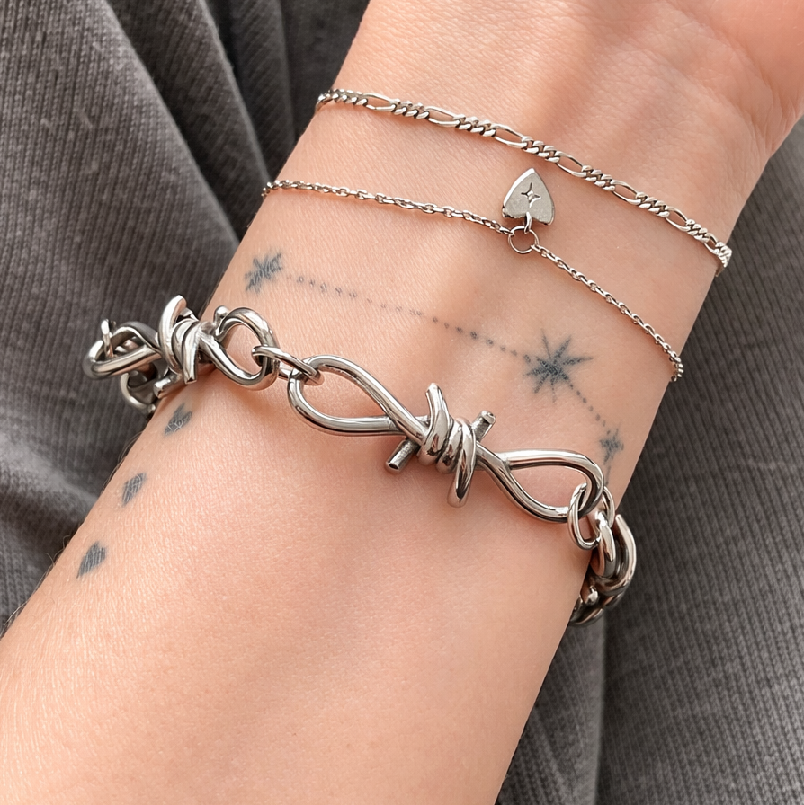Silver bracelet on a wrist with a gray background