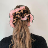 model wearing leopard scrunchie with pink ruffle trim