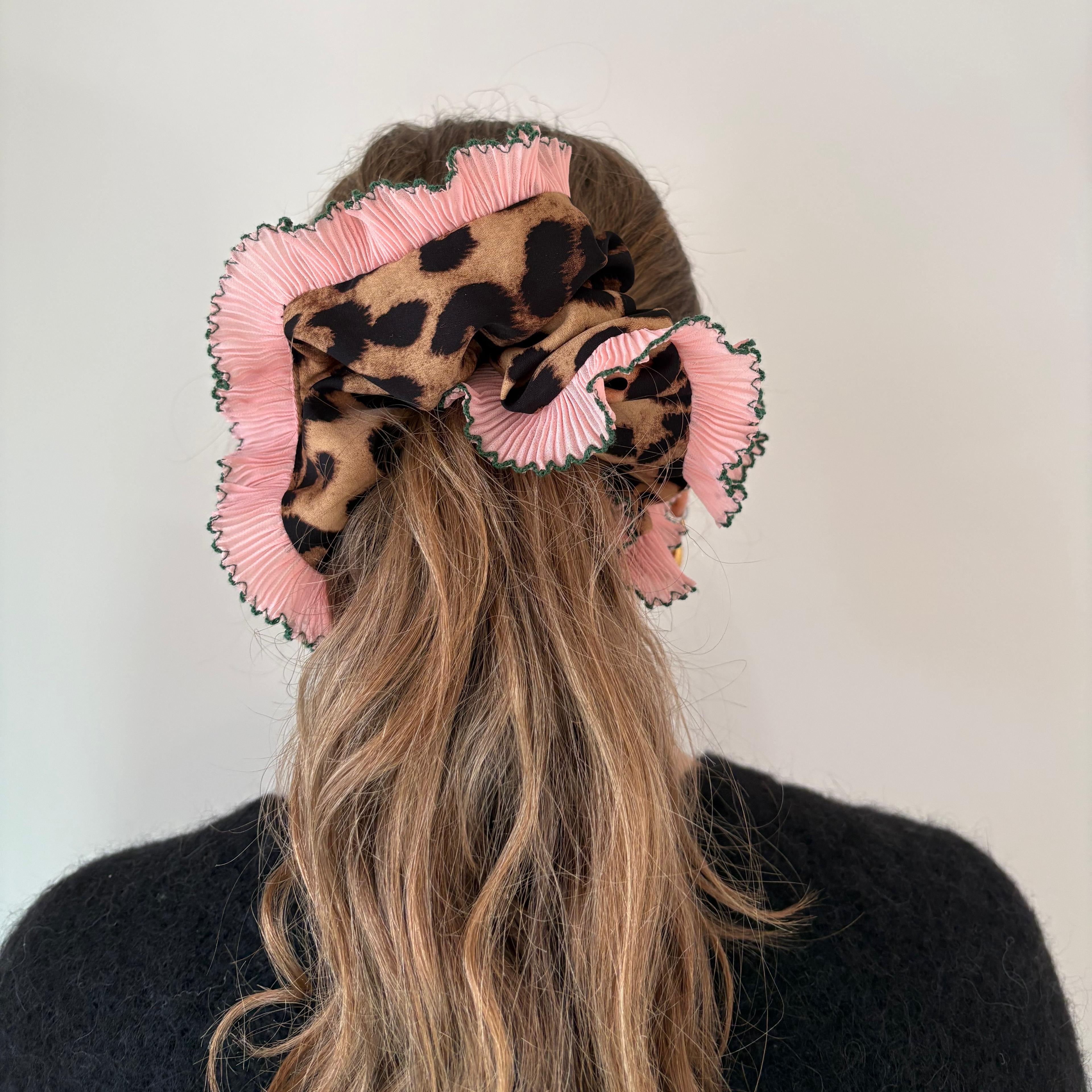 model wearing leopard scrunchie with pink ruffle trim