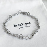 Silver bracelet on a white background with 'break out jewellery' branding.