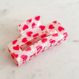 White hair clip with red hearts on 